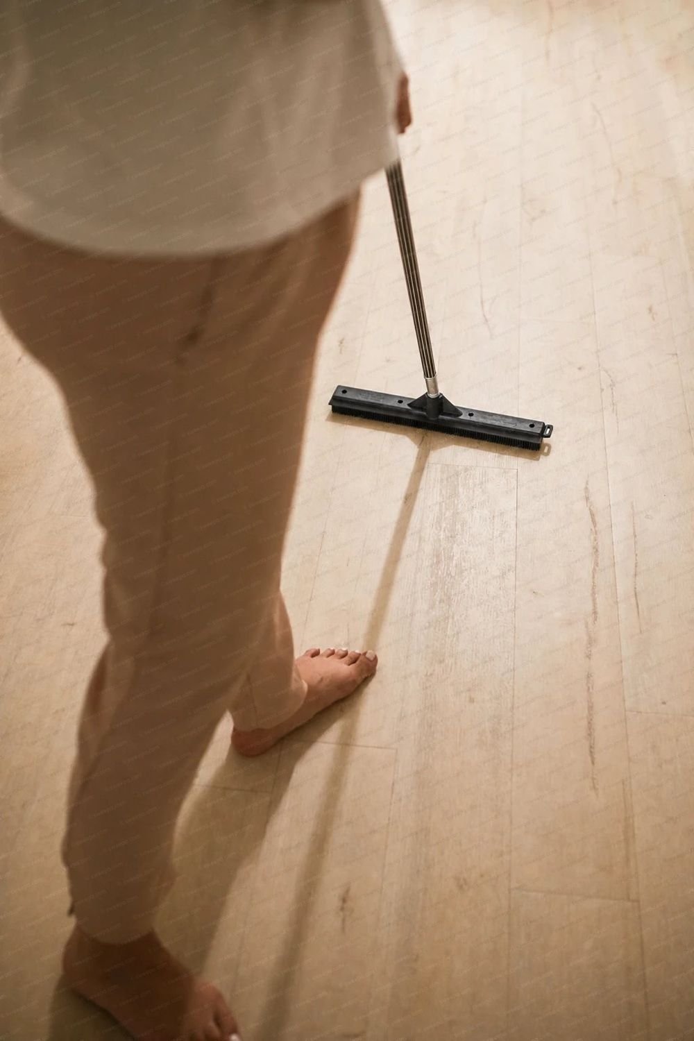 A Sweepa rubber broom in use on a wooden floor